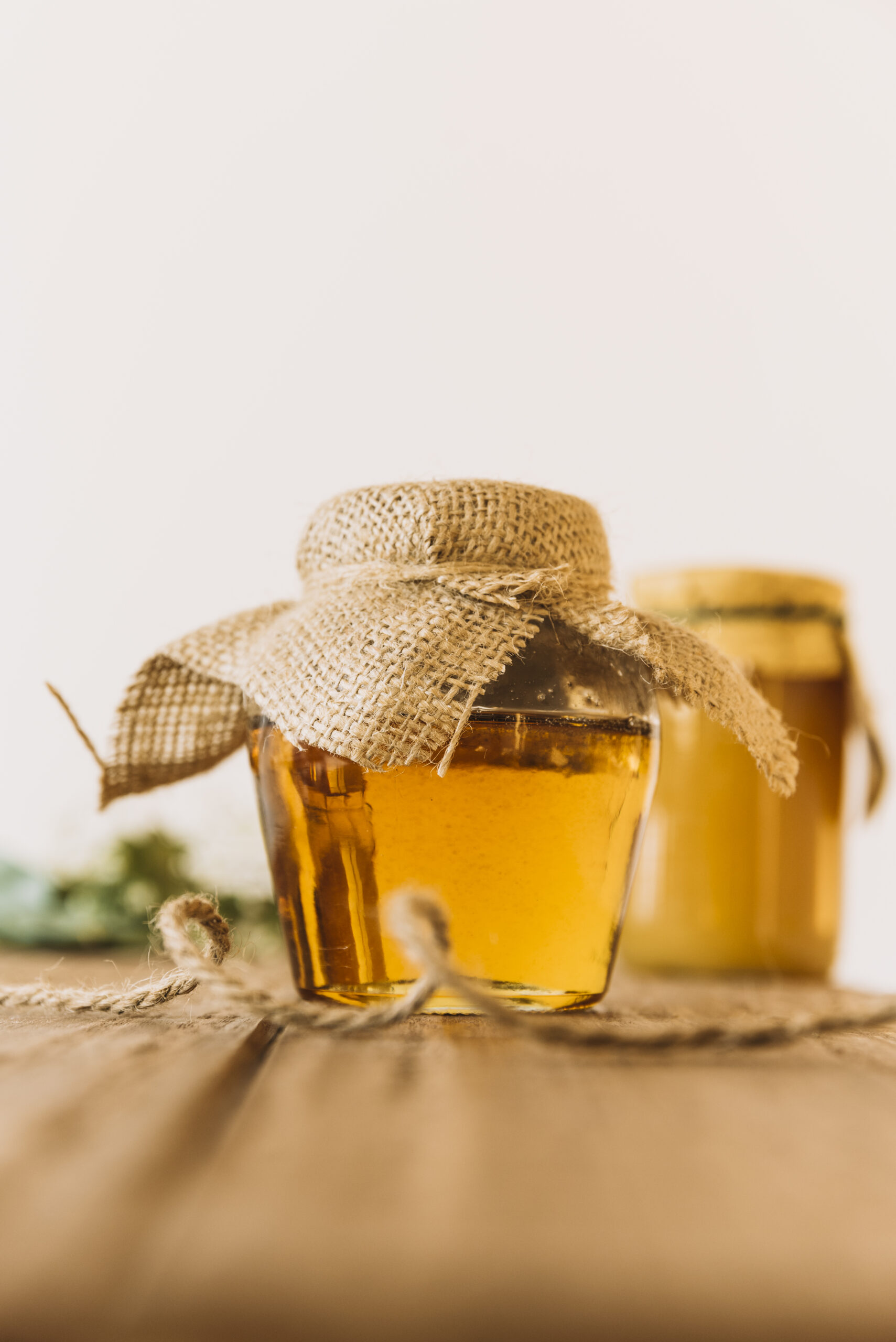 glass-jar-full-honey-wooden-table